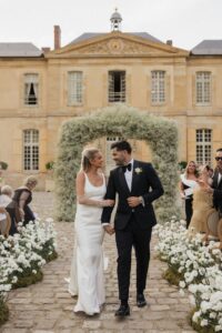 Hannah and Dylan exiting their wedding ceremony at Chateau de Villette in Condécourt, France