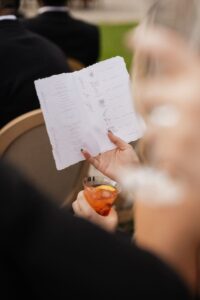 Guest reading a wedding program at Hannah and Dylan's wedding