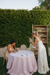 Hannah Godwin taking a video of Cat Lauren Calligraphy engraving room sprays for guests at her rehearsal dinner