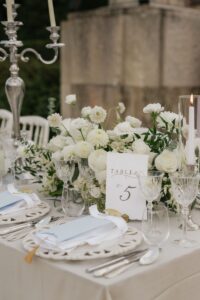 Detail shot of the tablescape at Hannah and Dylan's wedding, featuring a table number with custom calligraphy on handmade paper