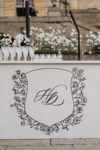 Close up shot of the hand drawn crest printed on the bar at Hannah and Dylan's wedding reception