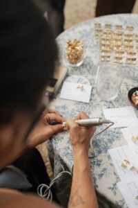 Close up of Cat Lauren Calligraphy personalizing cufflinks at Hannah and Dylan's wedding