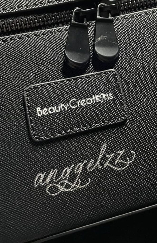 Hand lettering on black leather pouches for Beauty Creations