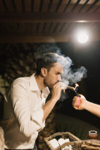The groom lighting a cigar that was custom rolled at the welcome party in Chable Yucatan