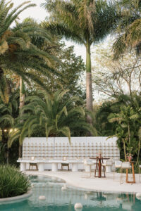Photo of tequila bottles used as unique wedding favors displayed in front of the lush greenery at Chable Yucatan