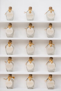 Detail image of bottles of Sotol displayed on a shelf to be used as custom wedding favors